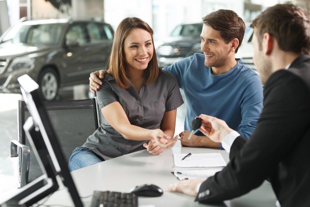 Couple receiving keys of bought car