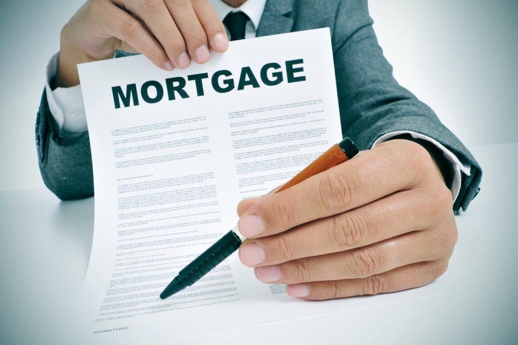 man holding a mortgage contract and a pen